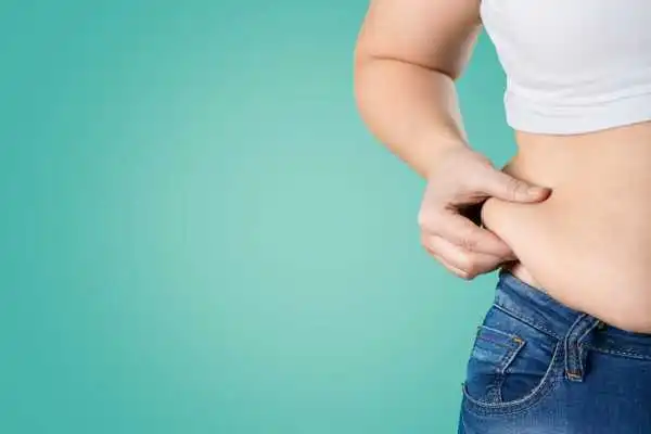 Image of woman pinching her love handles to show weight gain Stevenage Ware